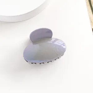 Gros plan d'une mini pince à cheveux ovale nacrée avec dégradé violet sur fond blanc