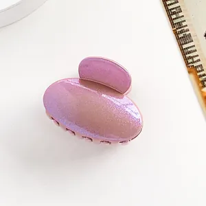Macro d'une petite pince à cheveux ovale violette nacrée avec finition métallique