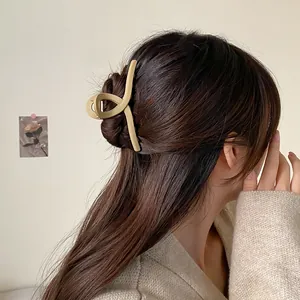 Grande pince à cheveux mate beige en forme de requin montrant une fixation solide