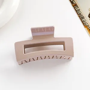 Vue de dessus d'une pince à cheveux carrée rose poudré avec finition brillante sur blanc