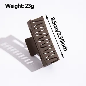 Pinza para el pelo marrón mate de 8,5 cm y 23g sobre fondo blanco, estilo minimalista
