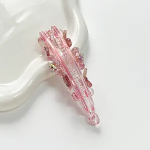 Vue macro d'une pince banane fleurie rose avec strass sur un plateau ondulé