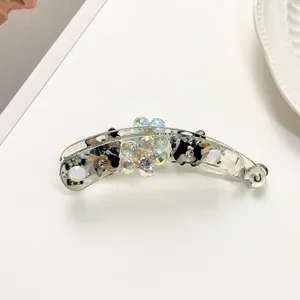 Détail de la grande pince banane avec des motifs écailles et des cristaux brillants
