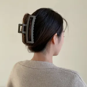 Pince à cheveux rectangulaire gris foncé mat montrée sur un modèle pour style automne