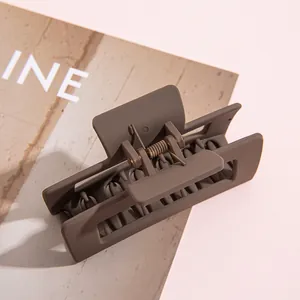 Primer plano de pinza para el cabello rectangular marrón moca mate con muelle metálico