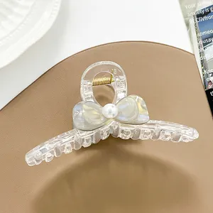 Detalle de pinza para el cabello transparente con lazo y perla en diseño elegante