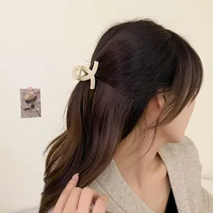 Haarklammer in Matt-Creme auf langem gewelltem Haar für einen minimalistischen Look