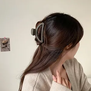 Pince à cheveux demi-cercle gris foncé mat portée sur une coiffure de femme