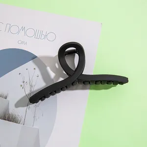Gros plan d'une pince à cheveux noire mate de 13 cm avec un design torsadé épuré