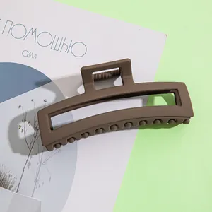 Gros plan d'une pince à cheveux rectangulaire marron mat sur un magazine mode
