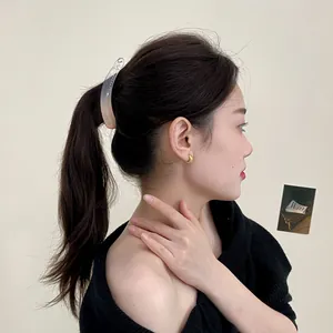 Minimalist transparent banana hair clip for a high ponytail on model from a side view