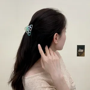 Cute acetate shark hair claw clip with blue and white marble pattern shown on hair