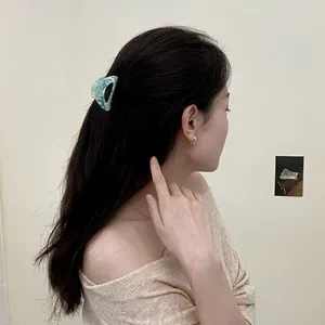Green marble acetate hair claw clip worn by a woman with a minimalist back view