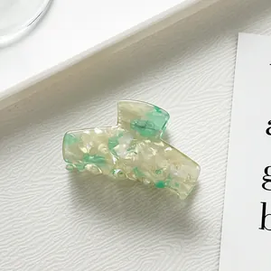 Détail macro d'une pince à cheveux en acétate vert menthe marbré avec finition brillante