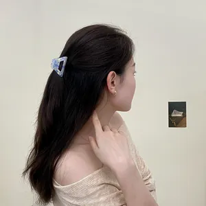 Pince à cheveux en acétate marbré bleu sur modèle aux longs cheveux bruns