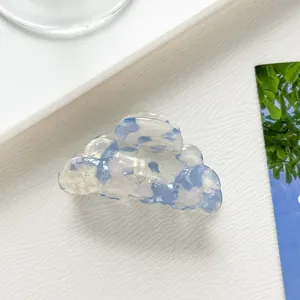 Dettaglio della molletta per capelli in acetato marmorizzato blu a forma di nuvola