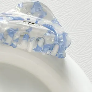 Detailed close-up of blue marble acetate hair claw clip showing smooth texture and metal spring