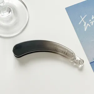 Close-up of a large banana hair clip featuring a smooth black and grey gradient finish