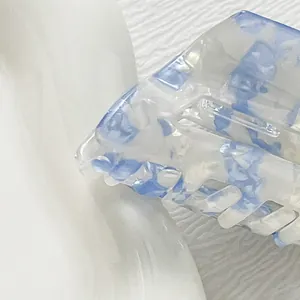 Vue détaillée de la pince à cheveux en résine bleue marbrée avec bords polis lisses