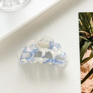 Macro view of wave-shaped blue and white acetate hair claw clip with marble texture