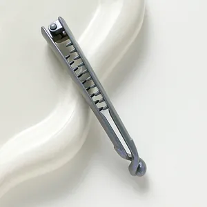 Detail of matte gray banana hair clip with secure teeth and sphere lock on ceramic tray