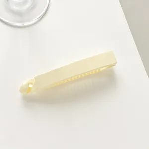 Close-up of cream banana hair clip showing its inner comb teeth and smooth finish
