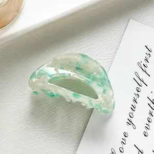 Detail of mint green marble pattern on a semicircular acetate hair claw clip for kids