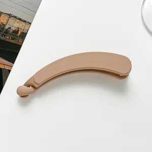 Detail of matte milk-tea colored banana hair clip showing its streamlined curved design