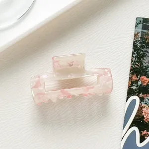 Close-up of a pink and white marbled acetate rectangular hair claw clip for elegant styles