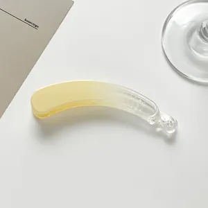 Detail of a minimalist yellow gradient banana hair clip with secure clasp mechanism