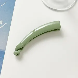 Close-up of a glossy mint green banana hair clip featuring a stylish knotted design