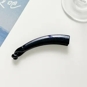 Macro detail of dark blue glitter banana hair clip with high-gloss resin finish