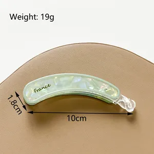 Pinza tipo banana de 10 cm en acetato verde claro con acabado nacré sobre base de cuero