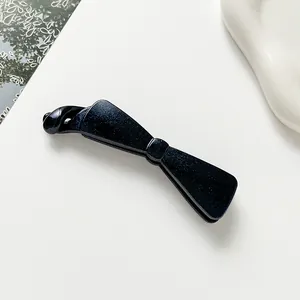 Détail macro d'une pince à cheveux nœud bleu foncé avec texture scintillante étoilée