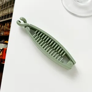 Detail view of the inner teeth and locking clip of a matte green banana hair clip