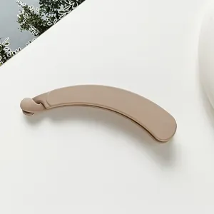 Macro shot of large matte beige banana hair clip with secure buckle and frosted texture
