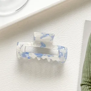 Macro detail of rectangle hollow hair claw clip with blue and white marble pattern