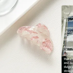 Detail der rosa Marmortextur auf kleiner Haarklammer aus Acetat mit glänzendem Finish