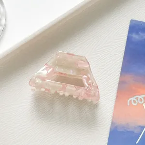 Gros plan sur la pince à cheveux en acétate marbré rose et blanc au design trapézoïdal