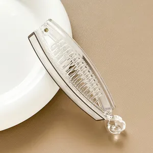 Detail of transparent banana hair clip with black trim on white ceramic plate