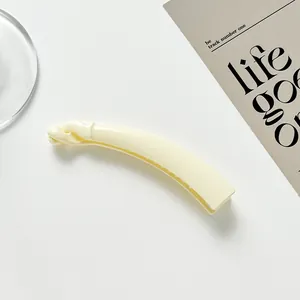 Glossy cream yellow banana hair clip detail on aesthetic card background minimalist setup