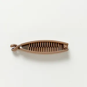Macro detail of brown banana clip showing interlocking teeth for thick hair styling