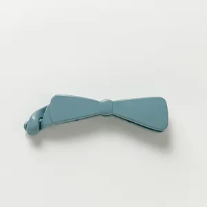 Macro detail of glossy Morandi blue banana hair clip with twist closure bow design