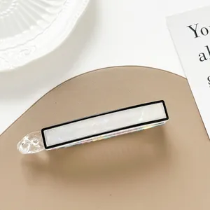 Detail of a large rectangular hair clip with white marble texture and pearlescent finish