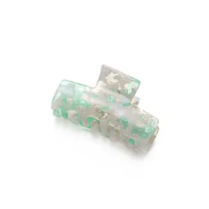 Pinza per capelli rettangolare in acetato con motivo marmorizzato verde e bianco su fondo bianco
