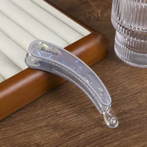 Detalle de pinza para el pelo tipo banana con textura de mármol, letras France y dientes