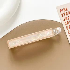 Detailed macro view of the iridescent pink shell texture on the large banana hair clip