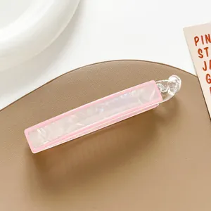 Detail of banana hair clip featuring pink marble texture and elegant border accents
