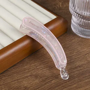 Detalle de la pinza banana rosa iridiscente con textura de mármol y letras France