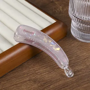 Detalle de pinza banana de acetato lavanda con textura de mármol y letras del logo France